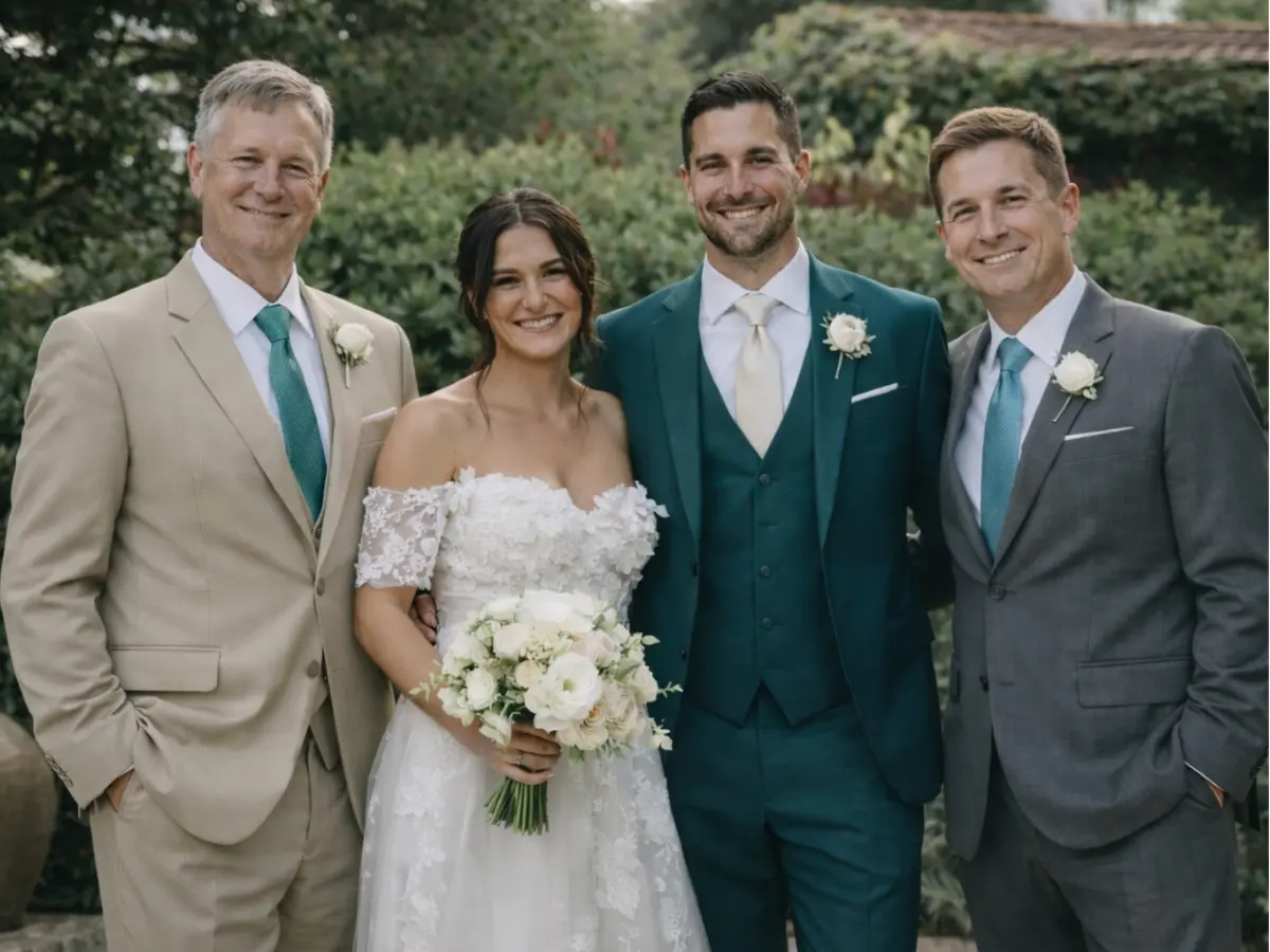 Noiva e noivo acompanhados pelos pais usando ternos em tons neutros e verde-azulado.