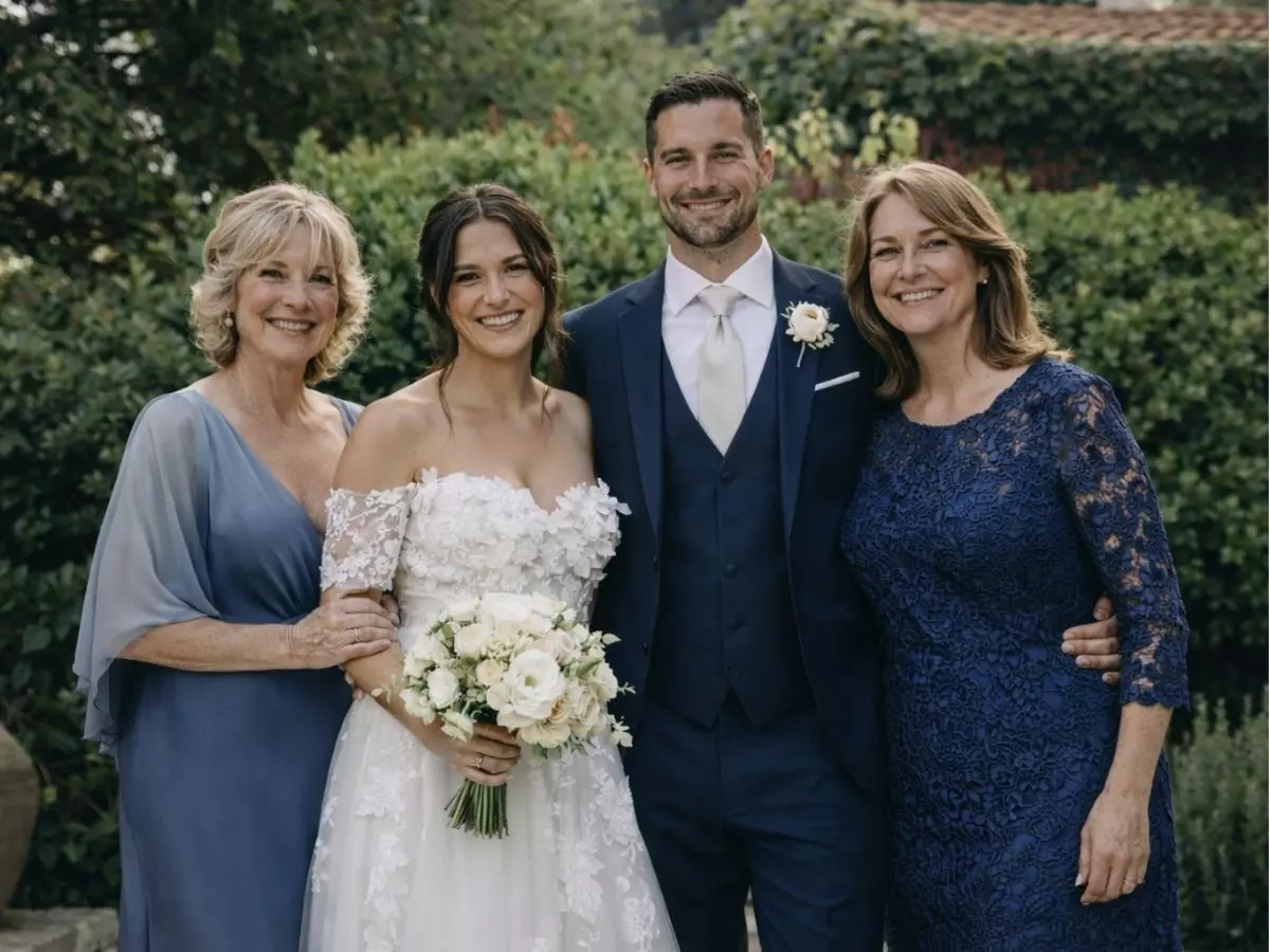 Noivos ao centro com mães usando vestidos em diferentes tons de azul em ambiente externo.