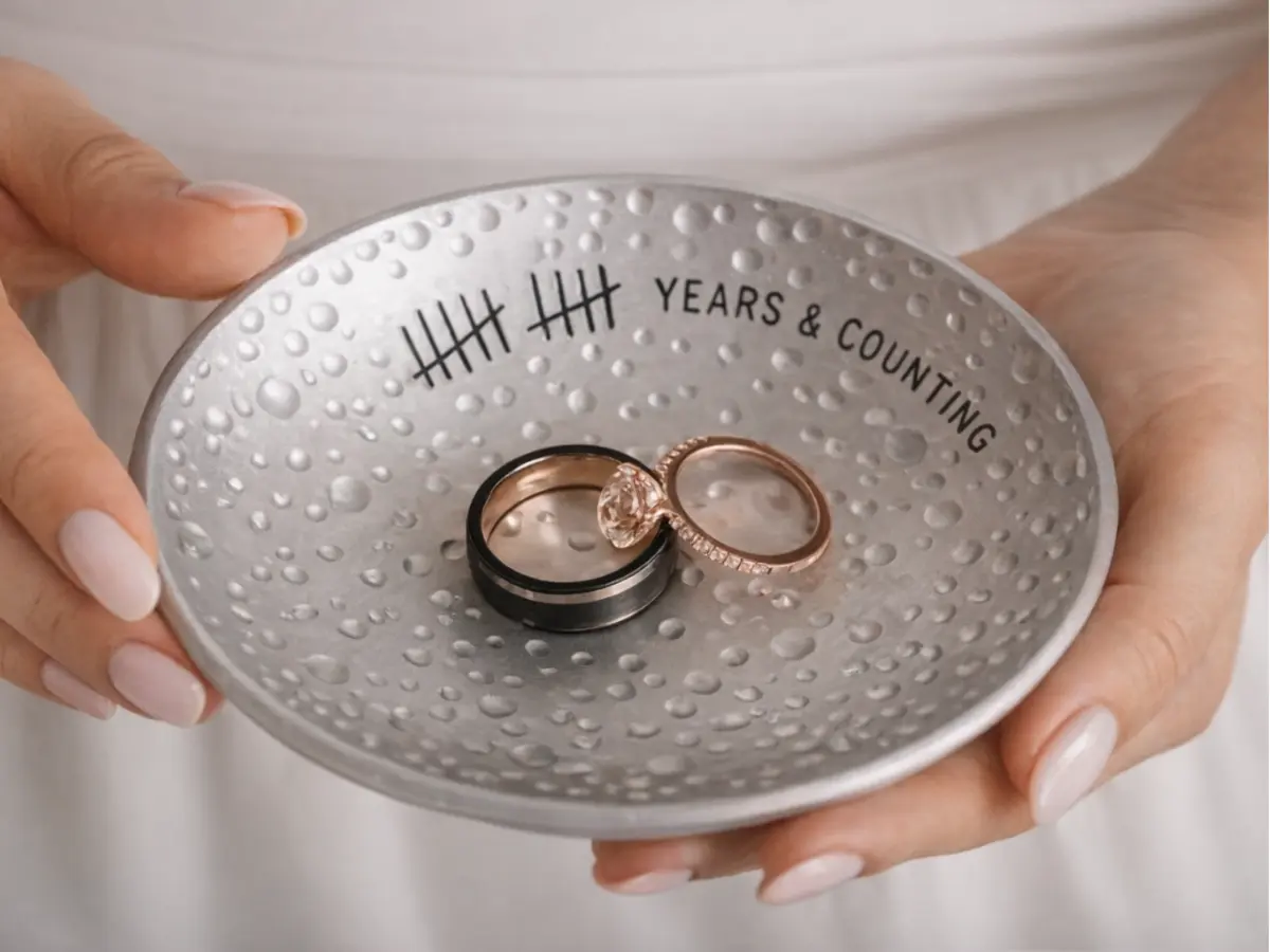 Alianças sobre prato metálico com inscrição years and counting