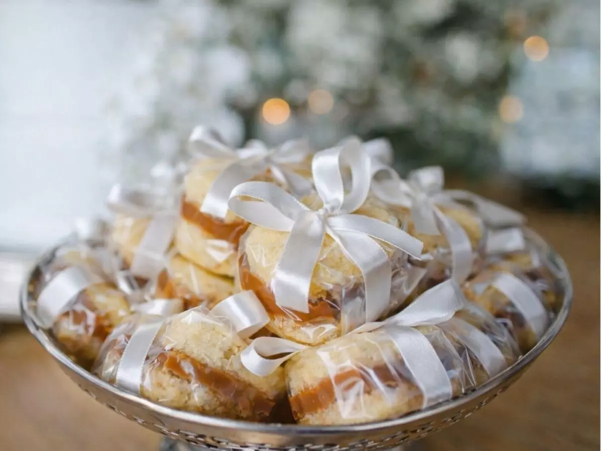 Bem-casados embalados individualmente com laço branco para lembrancinha de casamento