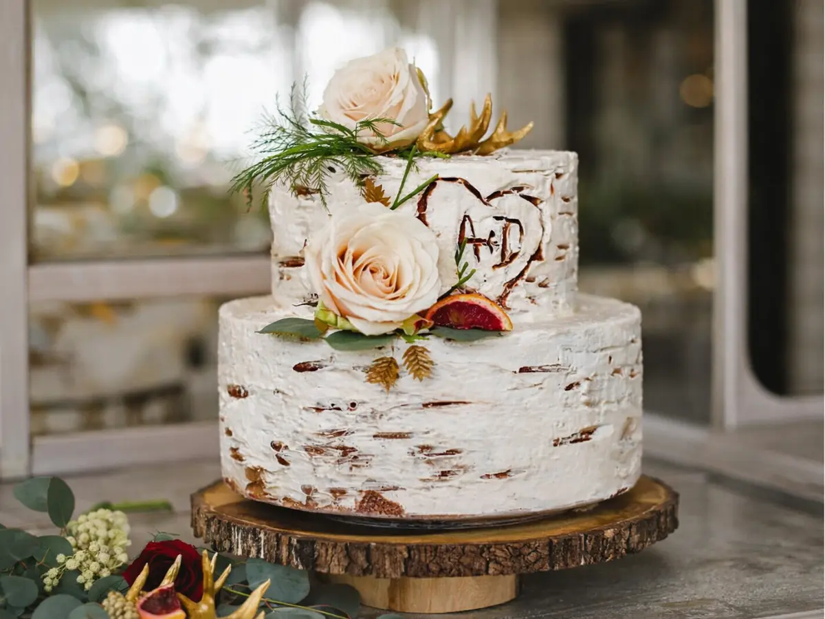 Bolo de casamento semi-naked com flores em tons suaves, detalhes naturais e base de madeira rústica.