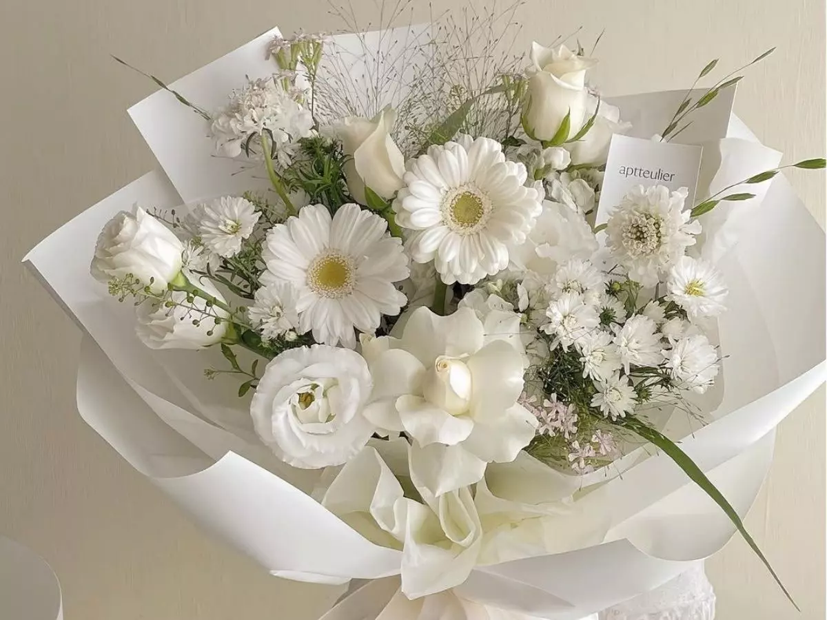 Buquê branco com gérberas, rosas claras e flores delicadas em embalagem elegante