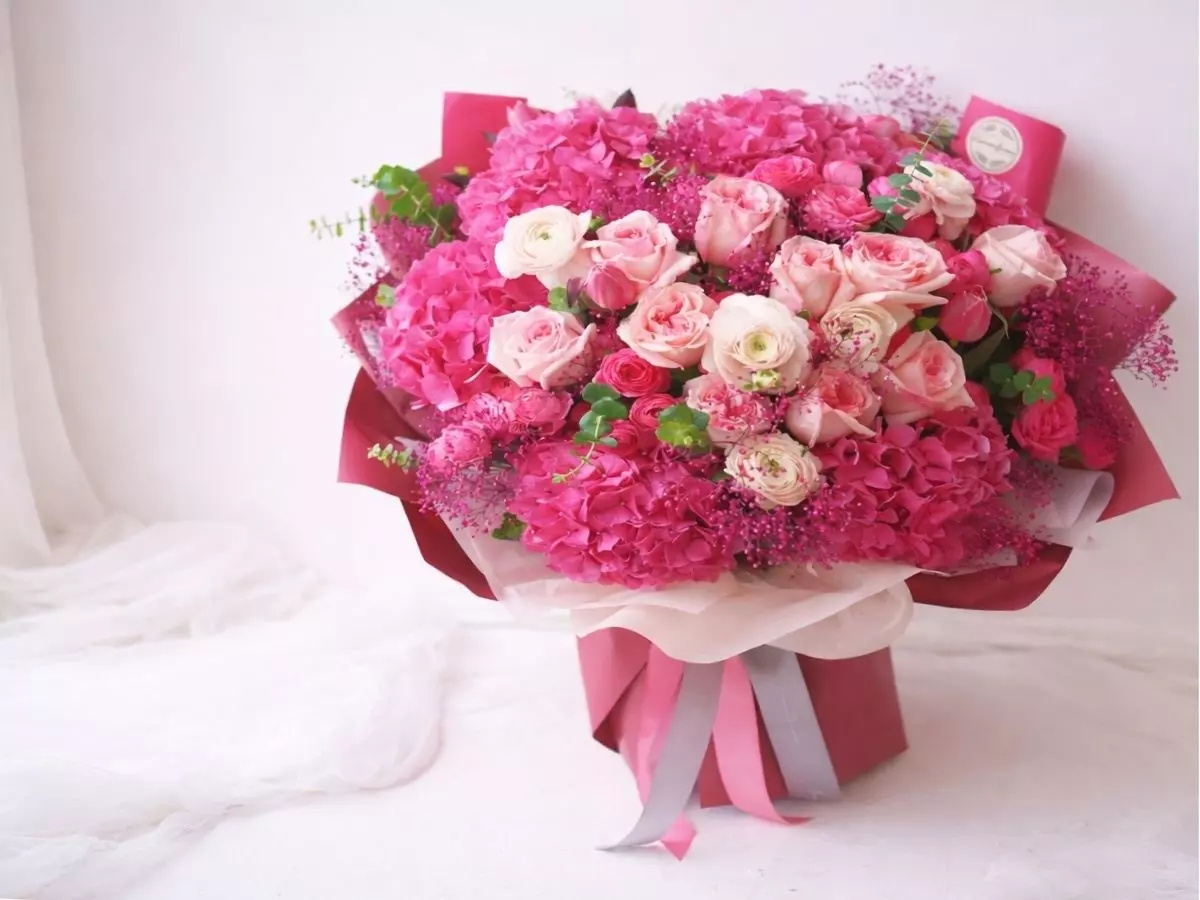 Buquê volumoso com hortênsias rosas e rosas claras em embalagem sofisticada