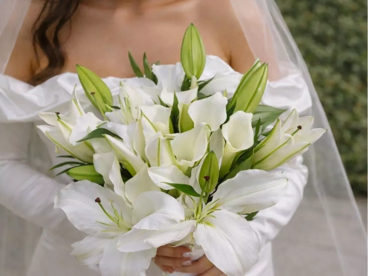 Buquê de noiva com lírios brancos abertos e botões verdes