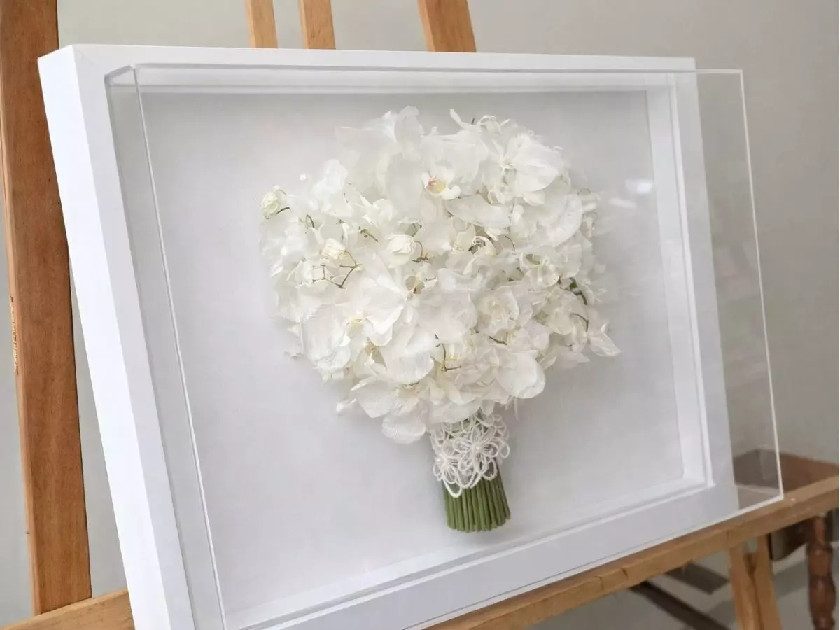 Buquê de noiva preservado em moldura com flores brancas