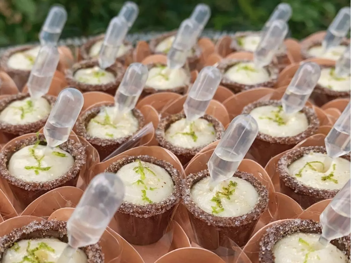 Doces para casamento de copinho com creme cítrico e pipeta decorativa servidos em mesa de casamento