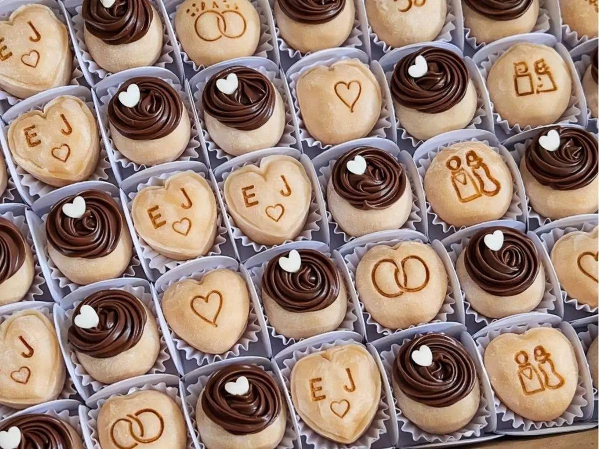 Doces personalizados com iniciais dos noivos e decoração em chocolate organizados em caixa para casamento