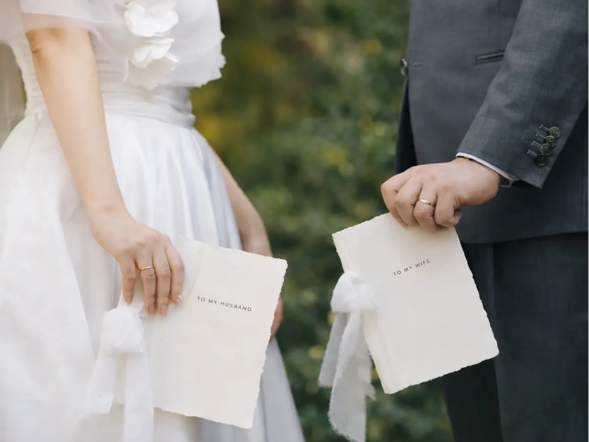 Noivos segurando cartas pessoais durante o casamento, registrando a troca de mensagens íntimas antes da cerimônia