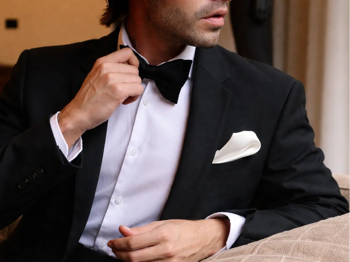 Lapela do Noivo ajustando gravata borboleta preta com lapela minimalista