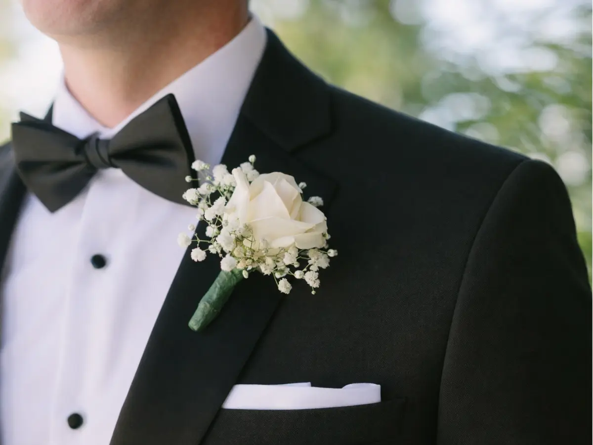Lapela para padrinhos clássica com rosa branca e mosquitinho em terno preto