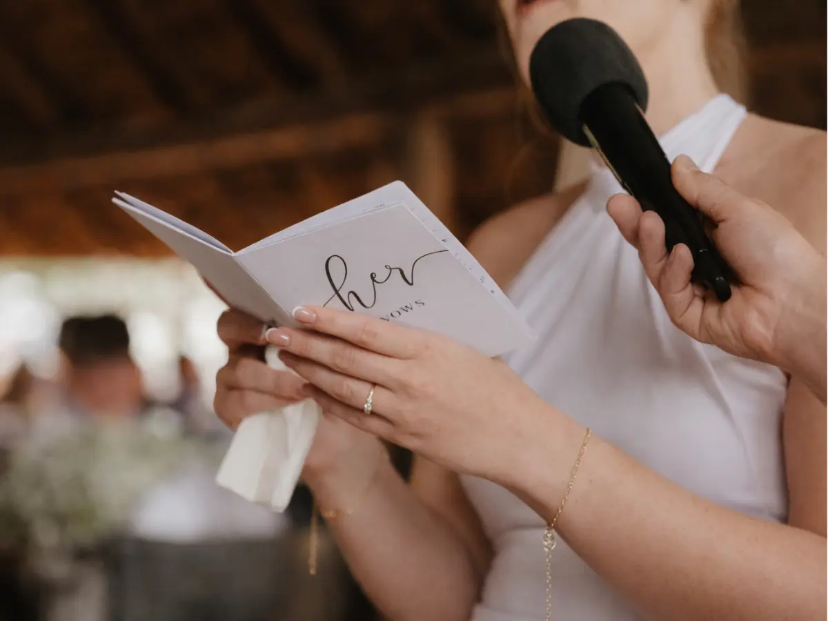 Noiva lendo votos de casamento ao microfone durante a cerimônia