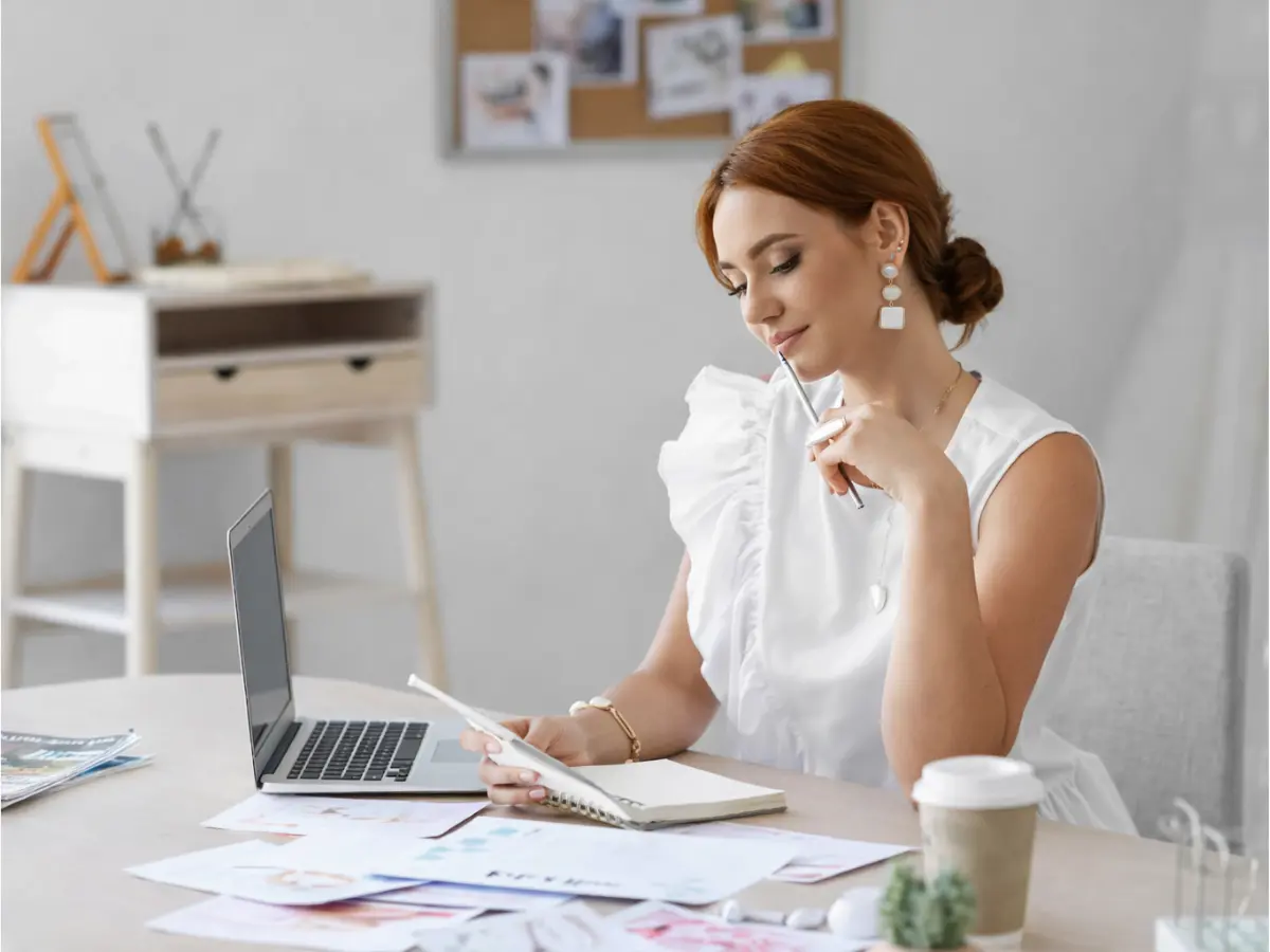 Mulher organizando lista e planejamento do chá de casa nova em mesa de trabalho