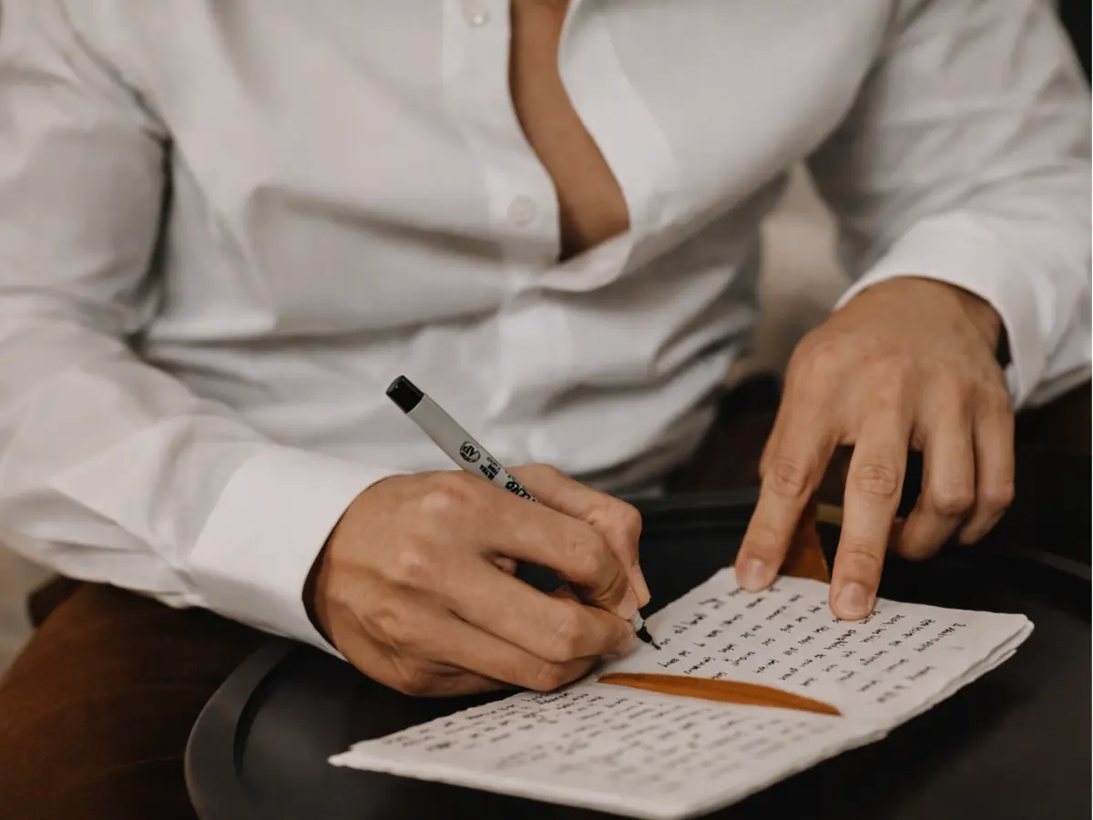 Noivo escrevendo seus votos de casamento em um caderno artesanal