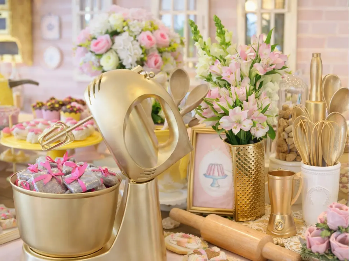 Mesa com presentes de chá de casa nova incluindo batedeira, utensílios e decoração