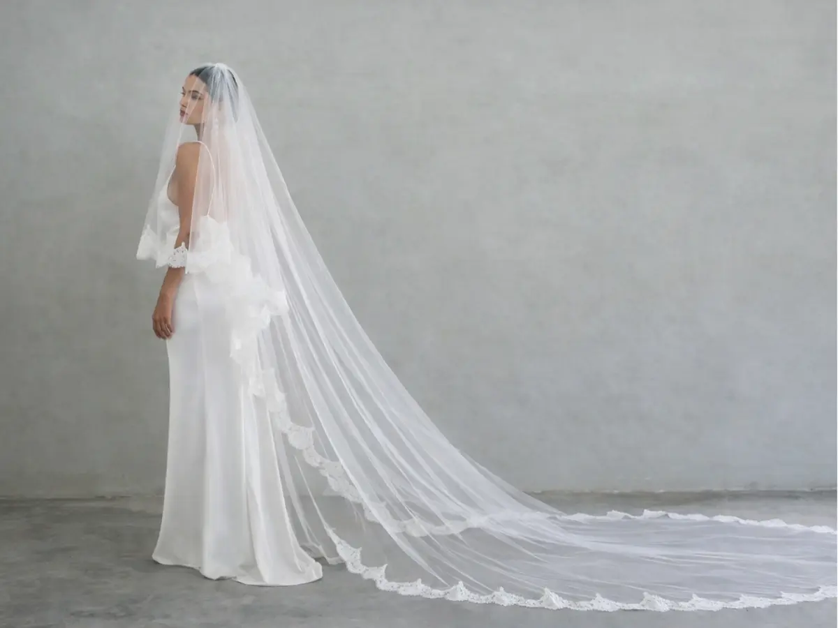 Noiva usando véu capela longo com acabamento delicado.
