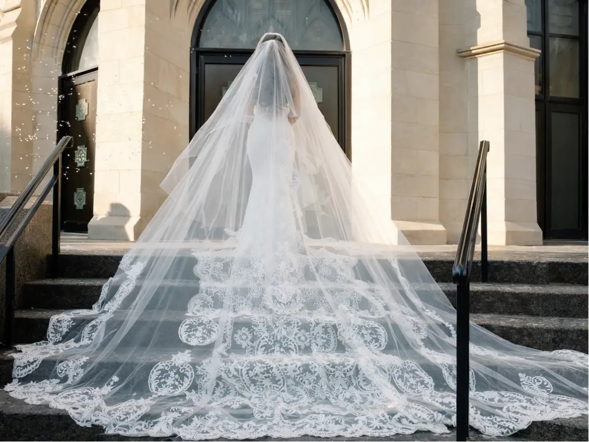 Noiva usando véu catedral longo com renda na borda, arrastando no chão.