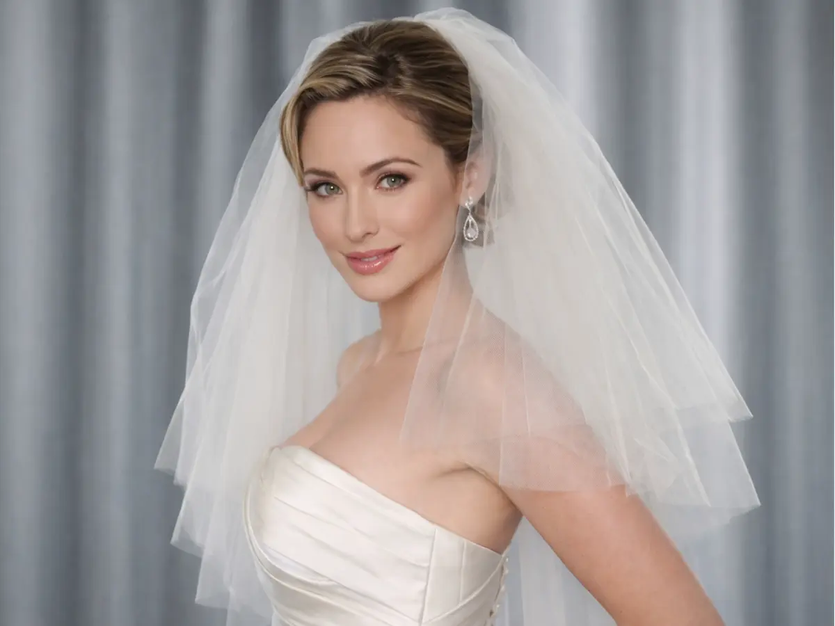 Noiva usando véu de comprimento médio na altura do cotovelo.